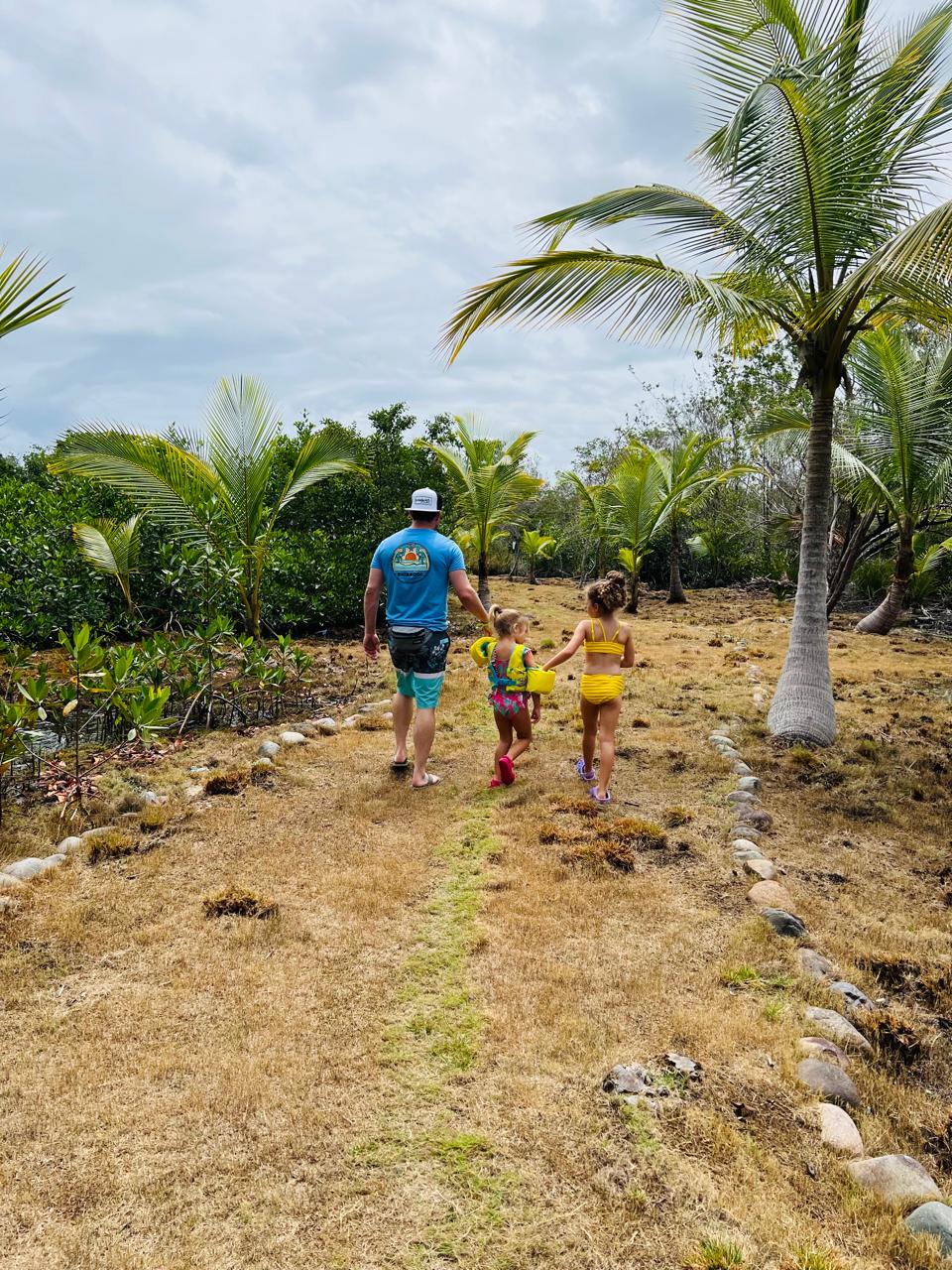 Guests walking a palm-lined island path at Sera Island Resort, Bocas del Toro