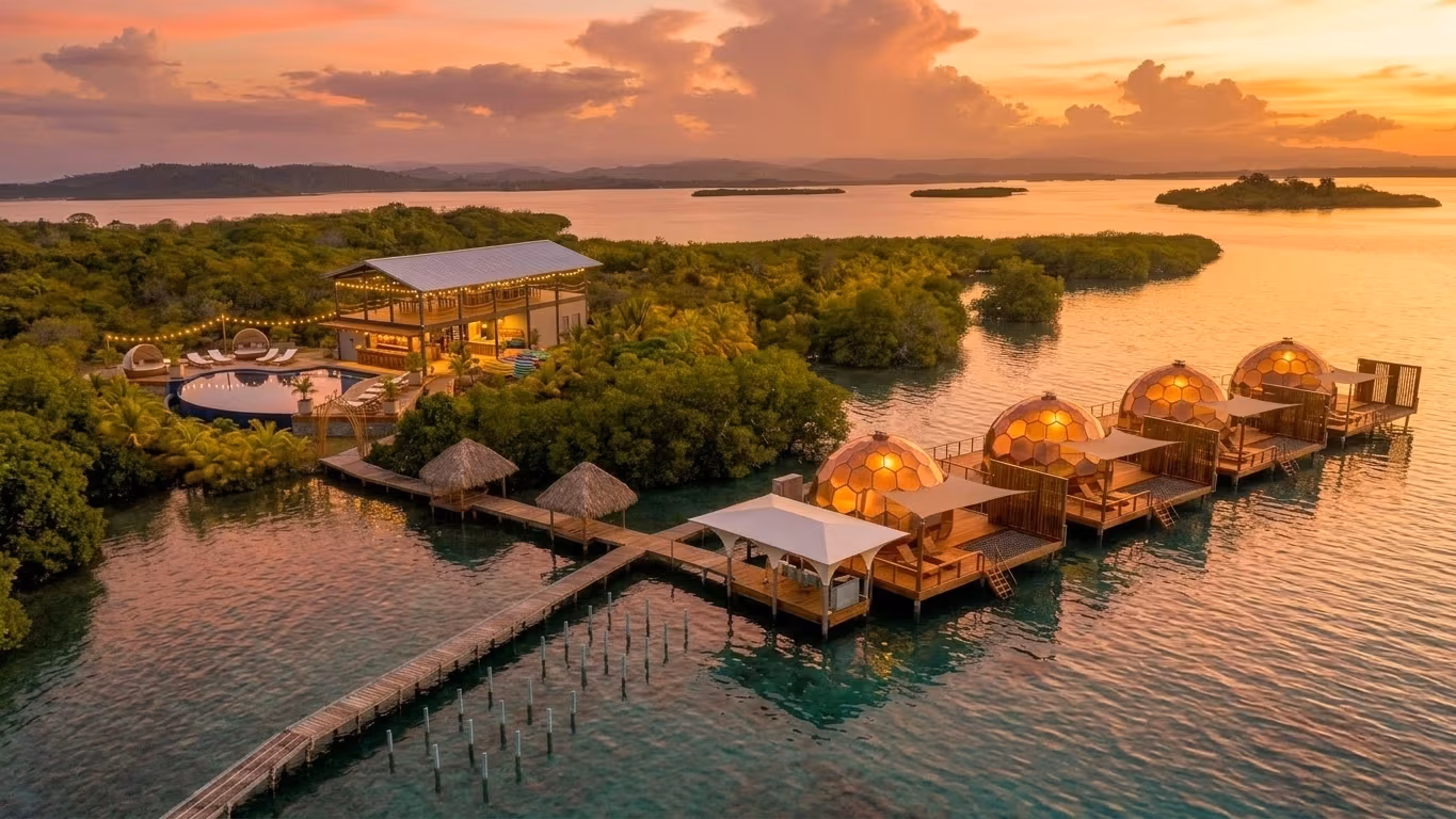 Render aéreo de domos de cristal sobre el agua brillando al atardecer, Bocas del Toro